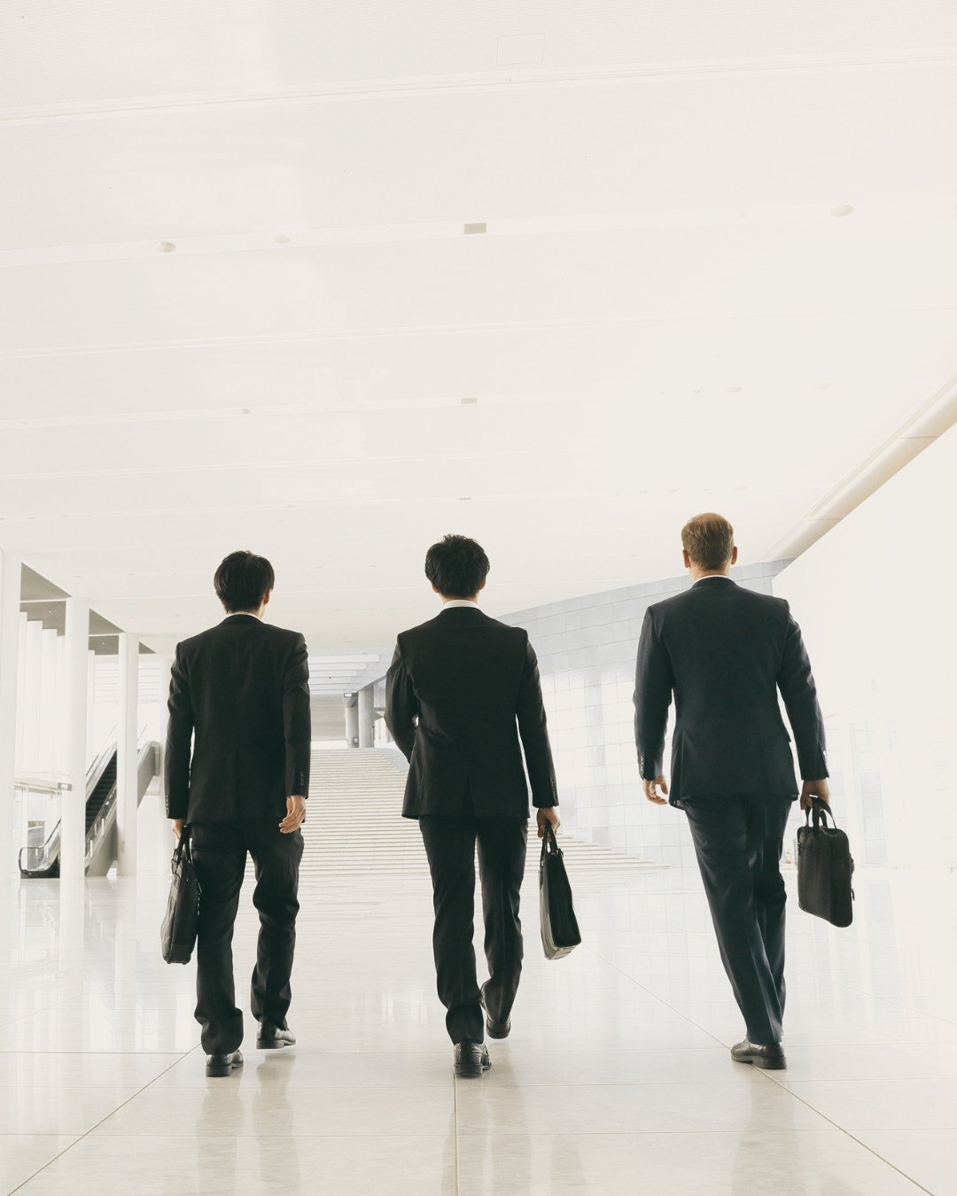 Three business owners walking through an airport with their briefcases